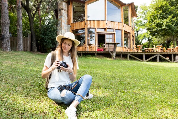 Woman sitting on grass and looking at her camera