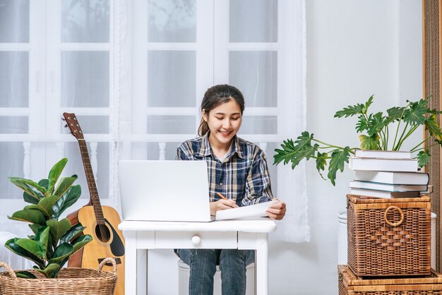 A woman sitting happily with a laptop at the table.