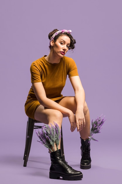 Woman sitting and having lavender flowers in boots