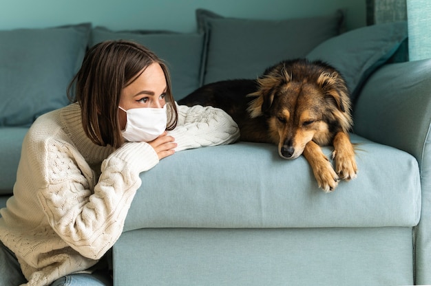 パンデミック時に自宅で犬の隣に座っている女性