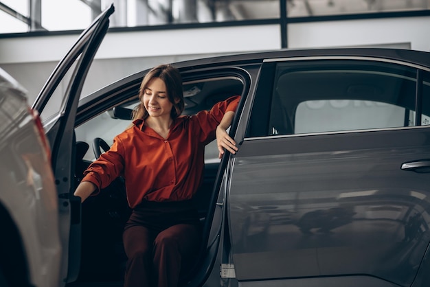 Free photo woman sitting in her new car