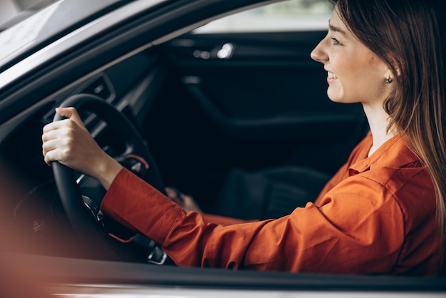 Free photo woman sitting in her new car