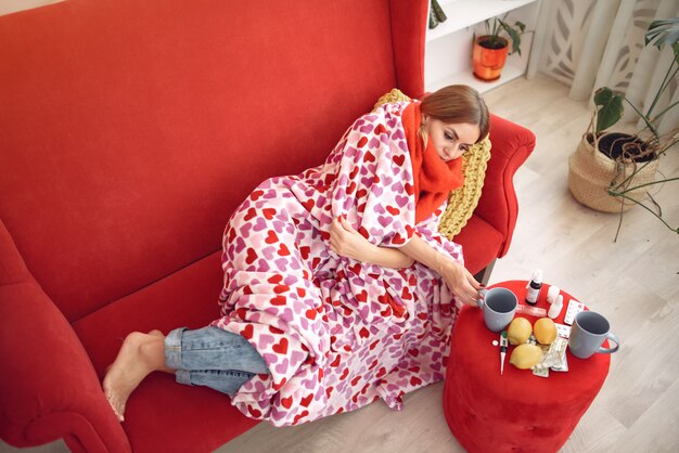 Woman sitting at home with a cold and drinking hot tea