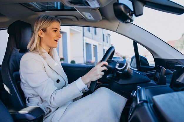 Woman sitting inside electro car while charging