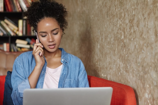 Donna seduta in una libreria con il suo laptop