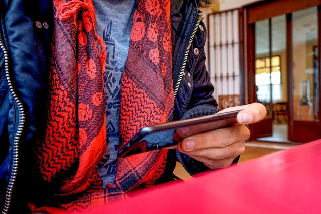 Woman sitting and looking through something on a modern smartphone