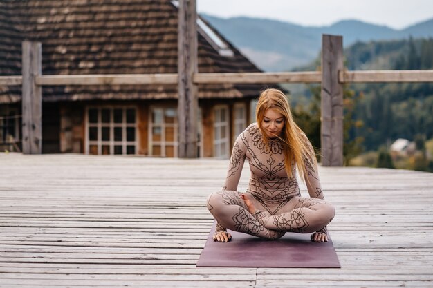 A woman sitting in lotus position at the morning on a fresh air.