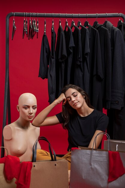 Woman sitting next to mannequin 