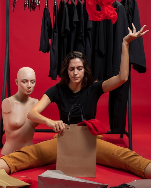 Woman sitting next to mannequin 