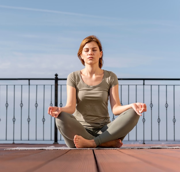 Donna seduta e meditando all'aperto