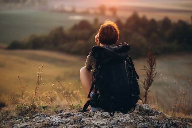 Free photo woman sitting on the mountain