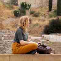 Free photo woman sitting near backpack