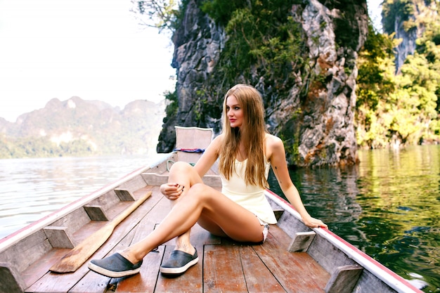 Woman sitting at old traditional Thailand boat end exploring national park Khao Sok