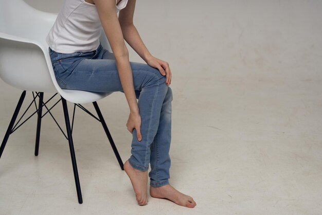 椅子に座っている女性と脚の痛み関節の健康上の問題。高品質の写真