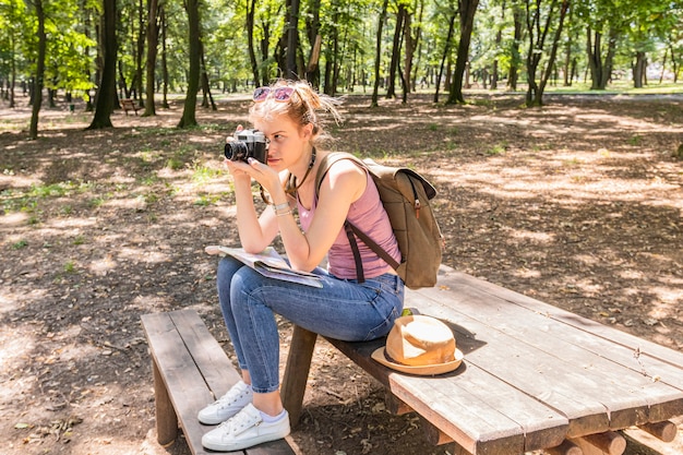 テーブルの上に座って写真を撮る女性