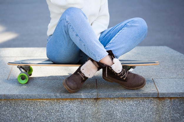 무료 사진 여자 다리 longboard에 앉아 넘어