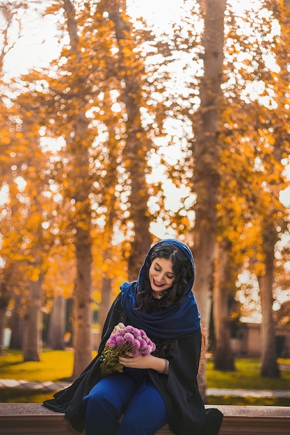 Woman sitting in the park and holding a bouquet of flowers