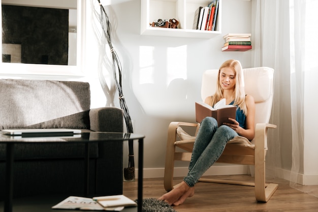 Woman sitting and reading book at home