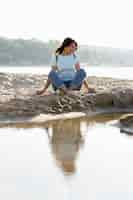 Free photo woman sitting on sand at the beach