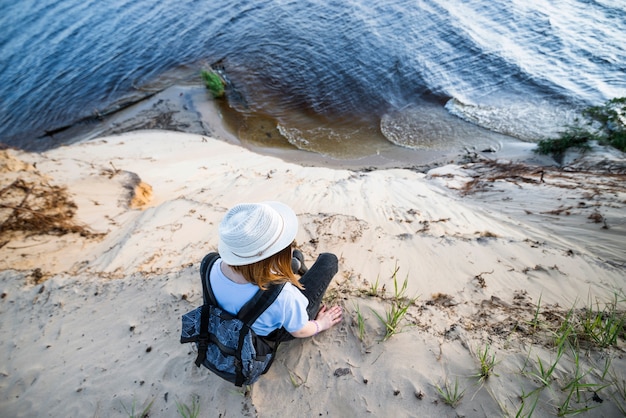 Free photo woman sitting on sandy cliff