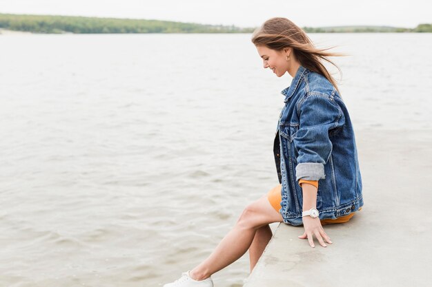 Woman sitting at seaside ponton