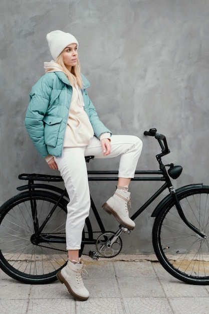 Женщина, сидящая боком на своем велосипеде