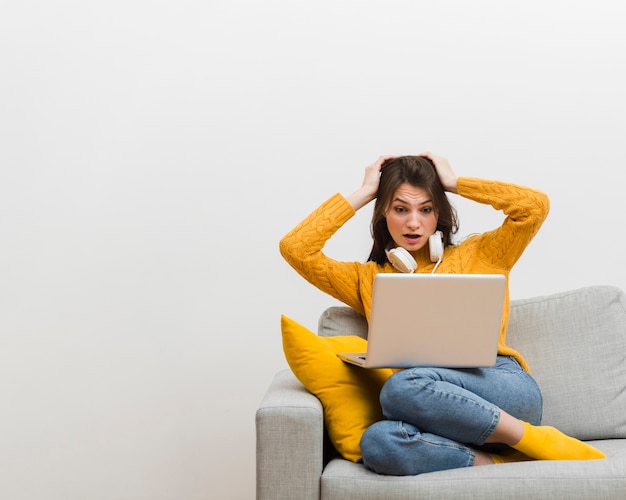 Woman sitting on sofa made a mistake on her laptop