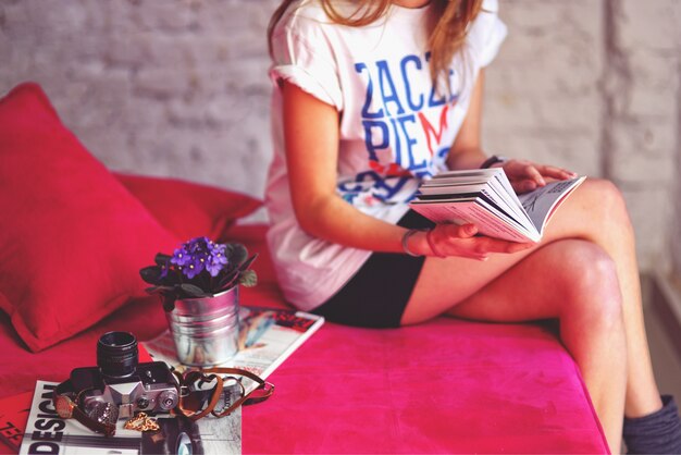 Woman sitting on a sofa reading a magazine