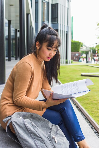 Woman sitting on stairs with documents 