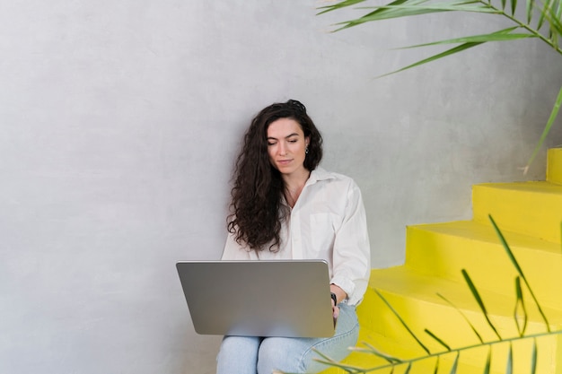 Woman sitting on the stairs and works