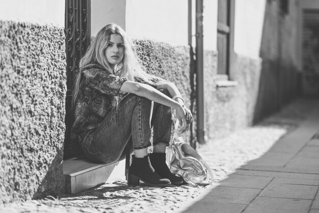 Woman sitting on the step of a door