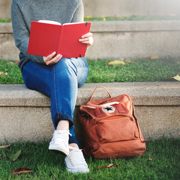 Free photo woman sitting on step holding notebook