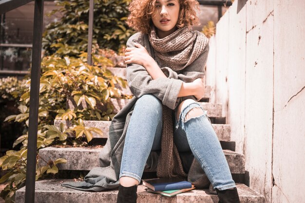 Woman sitting on steps with crossing hands