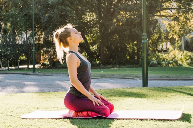 Foto gratuita donna che si siede sulla stuoia di stretching