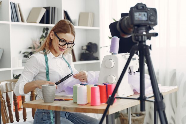 Woman sitting in studio and sew cloth