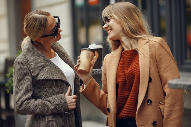 Woman sitting in a summer city and drinking coffee