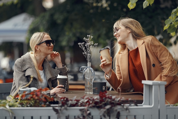 夏の街に座っていると、コーヒーを飲む女性