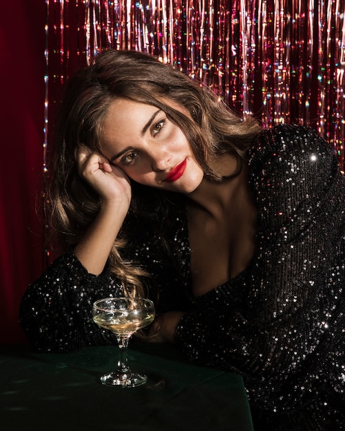 Woman sitting on a table with a glass of champagne