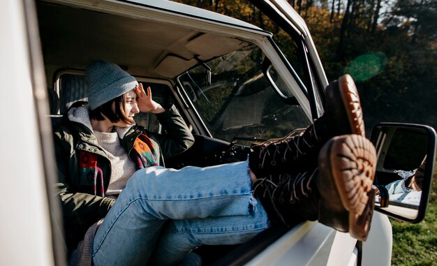 Woman sitting in a van with her legs out