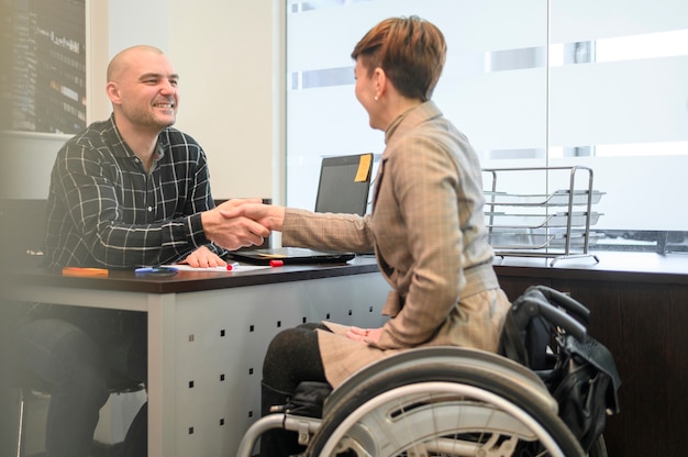 woman sitting in wheelchair shaking hands