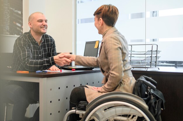 Woman sitting in wheelchair shaking hands