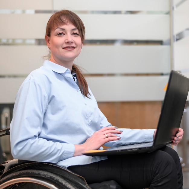 Woman sitting in wheelchair with laptop