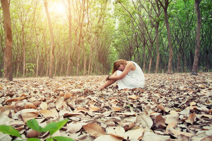 मुफ़्त फोटो woman sitting with her head resting on her knees
