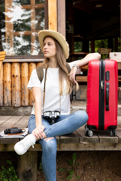 Woman sitting with her luggage and looking away