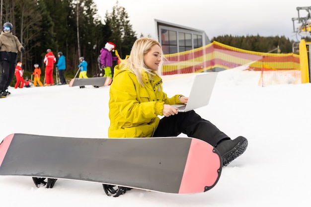 배경 풍경에 대 한 fa 겨울 산에 노트북과 함께 앉아 여자