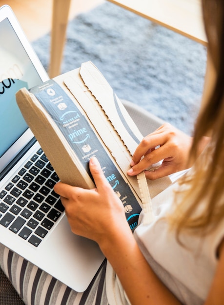 Woman sitting with laptop and opening delivery