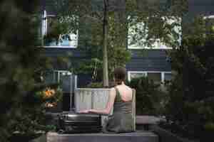 Free photo woman sitting with a suitcase in the park