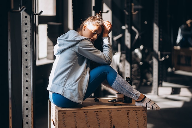 Free photo woman sitting on a wooden box at home