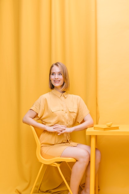 Free photo woman sitting in a yellow scene