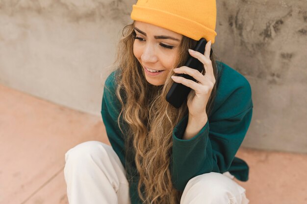 Free photo woman on skateboard talking over phone